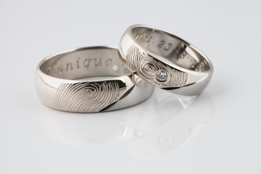 Een glanzended witgouden ring met een vingerafdruk en een briljant geslepen diamant die in de ring is gezet.