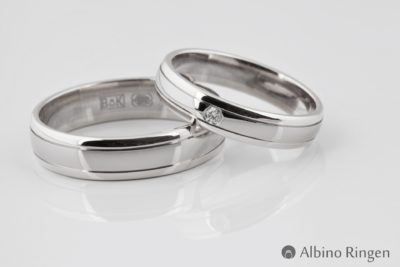 Een glanzende ring met twee lijn details en een briljant geslepen diamant.