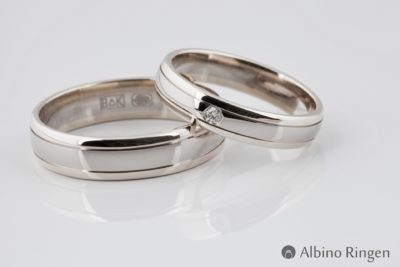 Een volledig glanzende ring gemaakt uit witgoud met lijndetails en een briljant geslepen diamant.